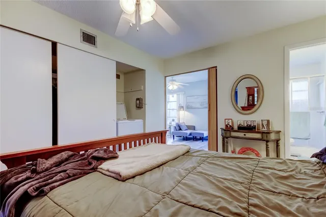 a bedroom with a bed and a large mirror on the dresser
