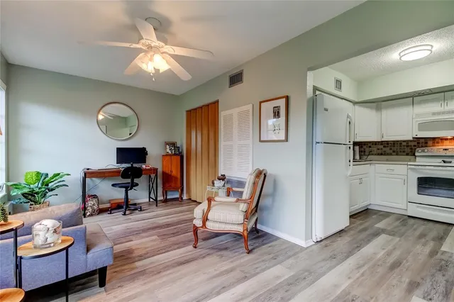 a living room with furniture and kitchen