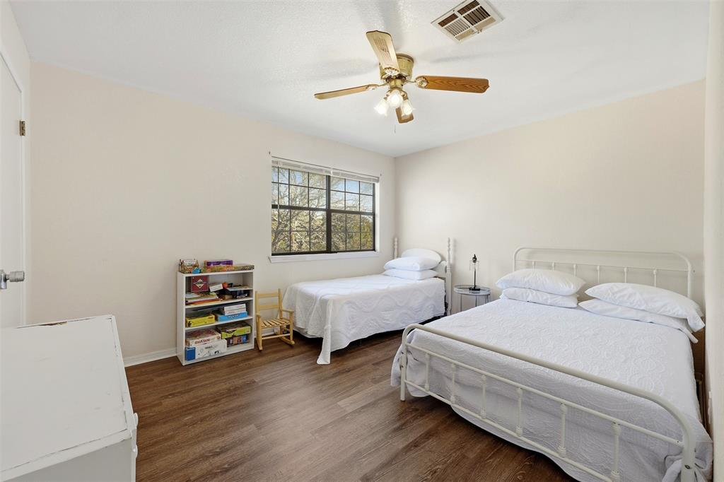 892 Hcr 1227 Whitney, TX 76692 - Photo 27 of 40 a bedroom with two beds and a chandelier