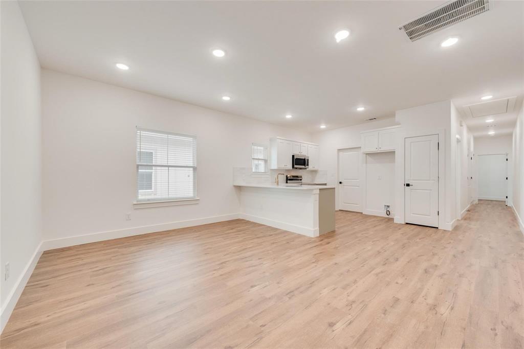 1807 Franklin Street Bonham, TX 75418 - Photo 2 of 13 a view of an empty room with wooden floor and a window