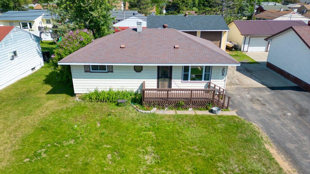 209 Brandon Road Hoyt Lakes, MN 55750 - Photo 1 of 38 Back of house featuring an outbuilding, a shingled roof, a yard, driveway, and a residential view