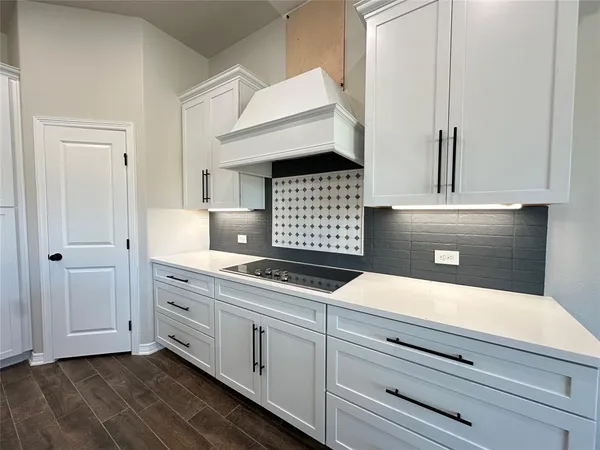 a kitchen with white cabinets and sink