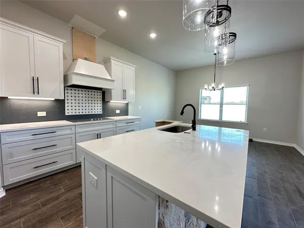 a kitchen with kitchen island granite countertop stainless steel appliances and wooden floor