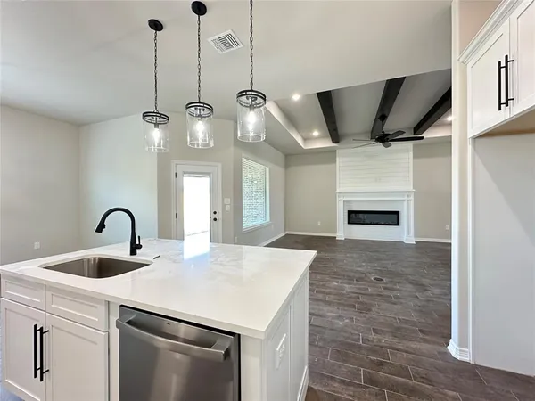 a kitchen with a sink a fireplace and wooden floor
