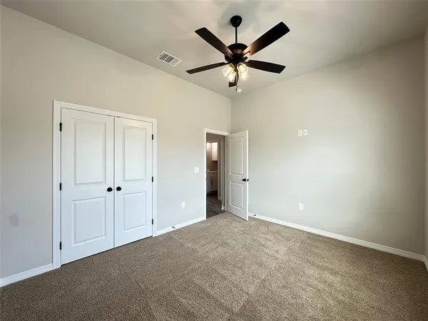 an empty room and chandelier fan