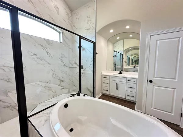 a bathroom with a tub sink and mirror