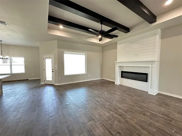 a view of empty room with wooden floor and fireplace