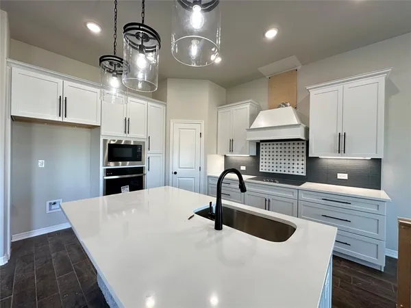 a kitchen with stainless steel appliances a sink a stove and a wooden floors