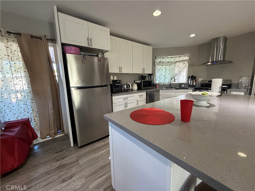 2601 East Victoria Street, Unit 404 Compton, CA 90220 - Photo 15 of 30 a kitchen with stainless steel appliances granite countertop a refrigerator sink and wooden cabinets