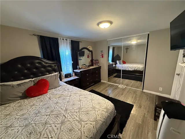 a bedroom with a bed and flat tv screen on the dresser