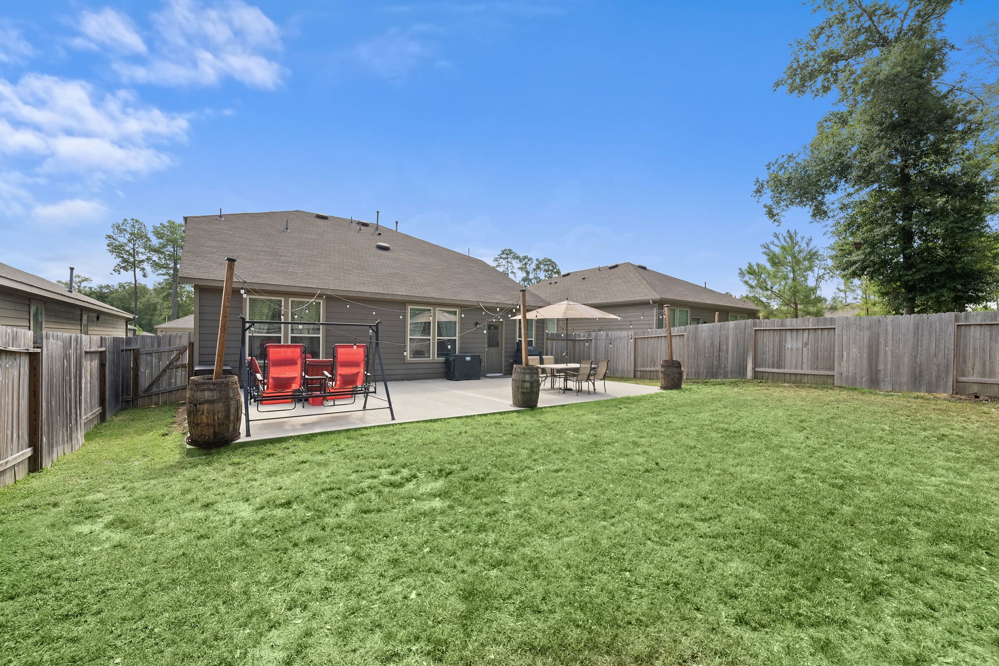 4210 Amber Ruse Drive Conroe, TX 77304 - Photo 43 of 45 This photo shows a spacious backyard, a large patio with fence for privacy. Perfect for relaxation and entertaining.