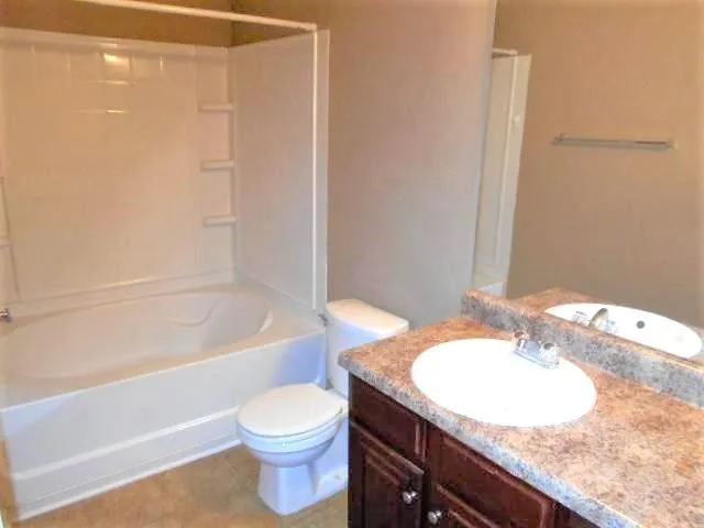 a view of a house with a yard and lawn chairs