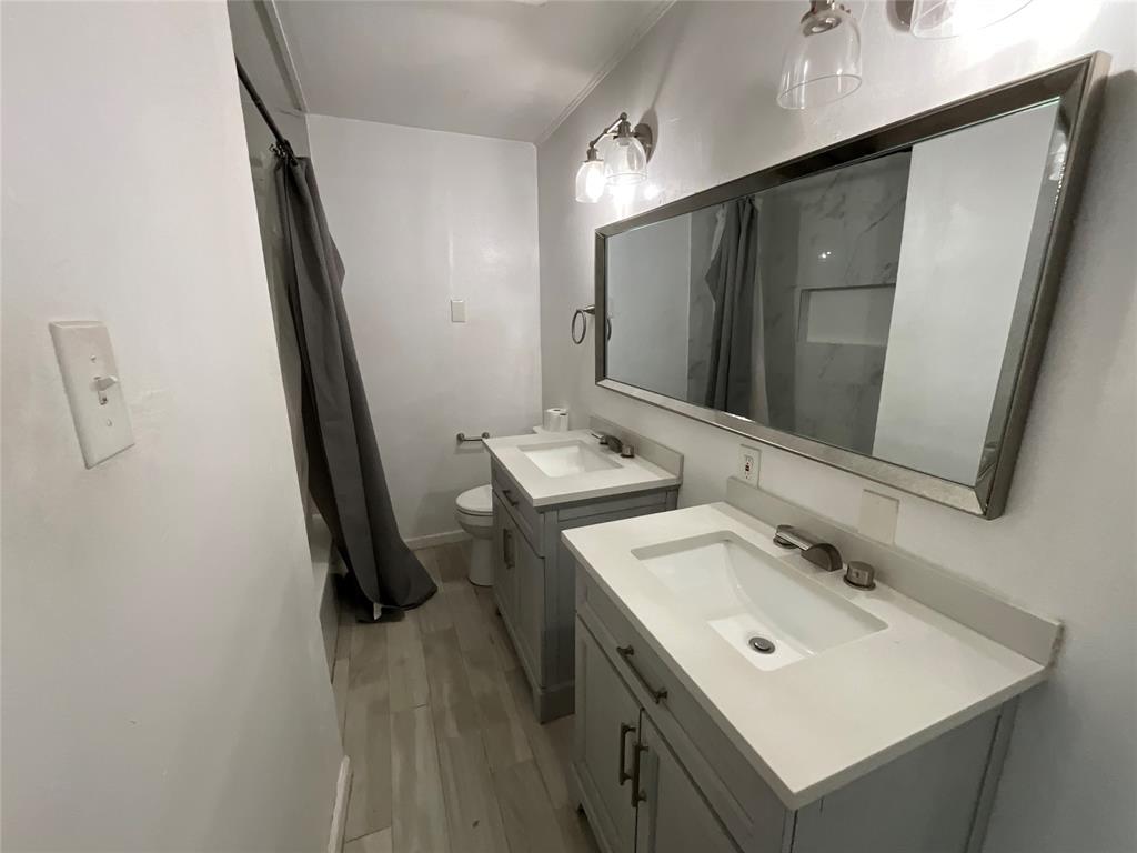 629 Harrison Lane Hurst, TX 76053 - Photo 10 of 20 a bathroom with a sink a mirror and a toilet