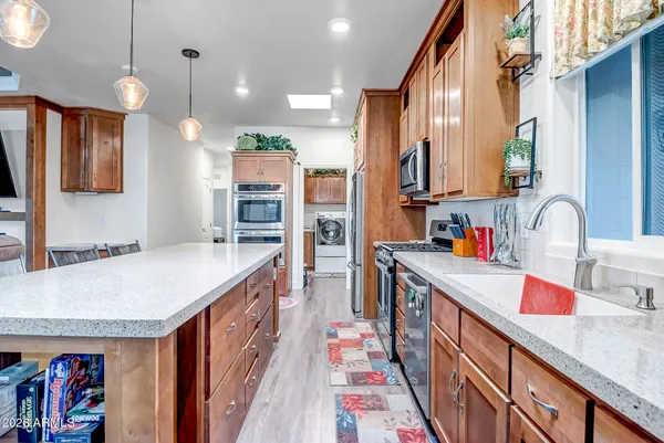a kitchen with kitchen island granite countertop a sink and cabinets