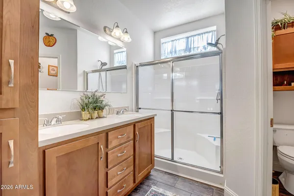 a bathroom with a granite countertop sink mirror and a shower