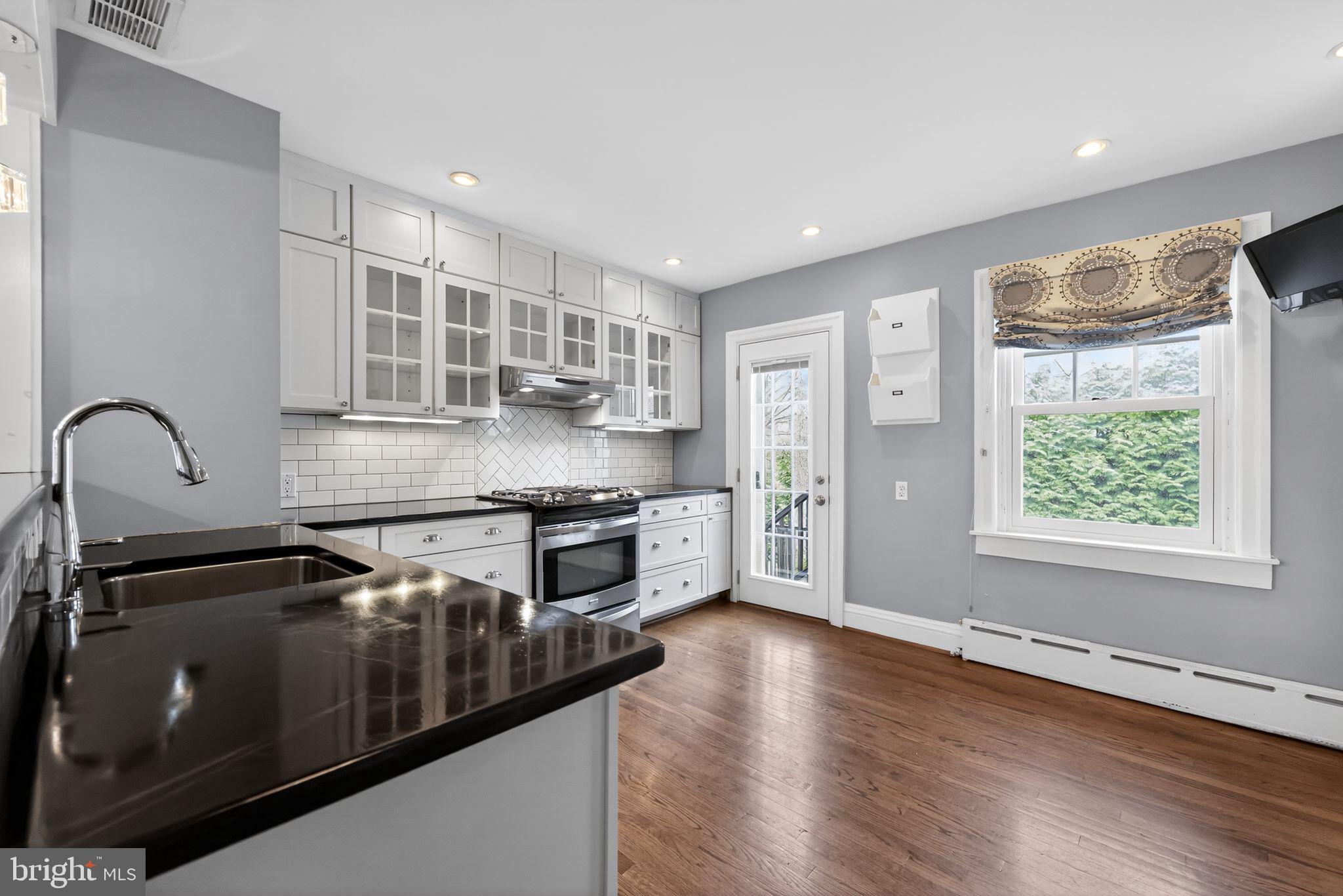 522 Dudley Avenue Narberth, PA 19072 - Photo 21 of 40 a kitchen with stainless steel appliances granite countertop a stove a sink and a microwave
