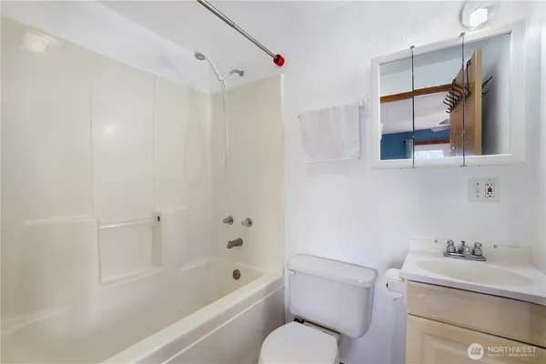 a bathroom with a sink toilet vanity and shower