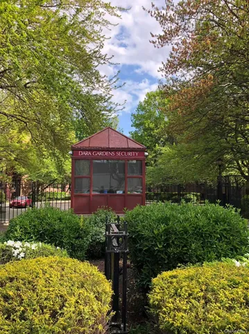 a view of a big yard next to a building with large trees