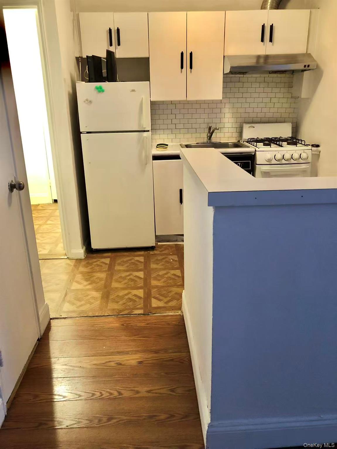 150-25 72nd Road, Unit 1L Queens, NY 11367 - Photo 4 of 12 a kitchen with refrigerator a stove and a sink