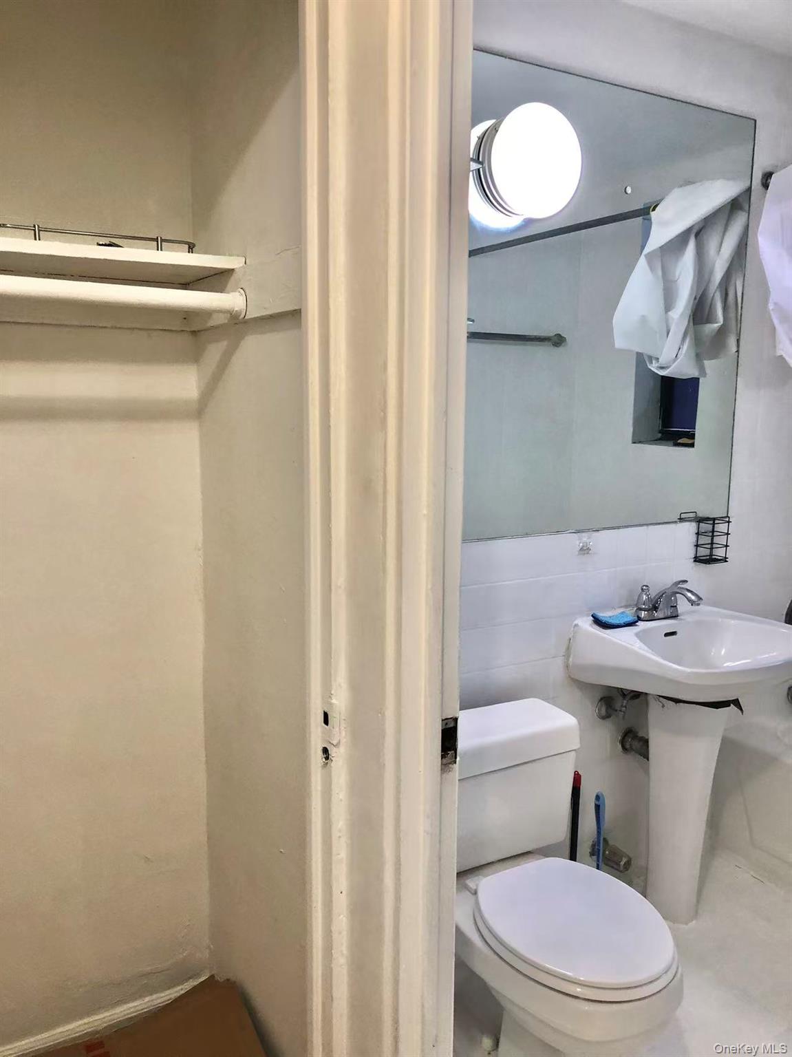 150-25 72nd Road, Unit 1L Queens, NY 11367 - Photo 7 of 12 a bathroom with a sink a toilet and a mirror