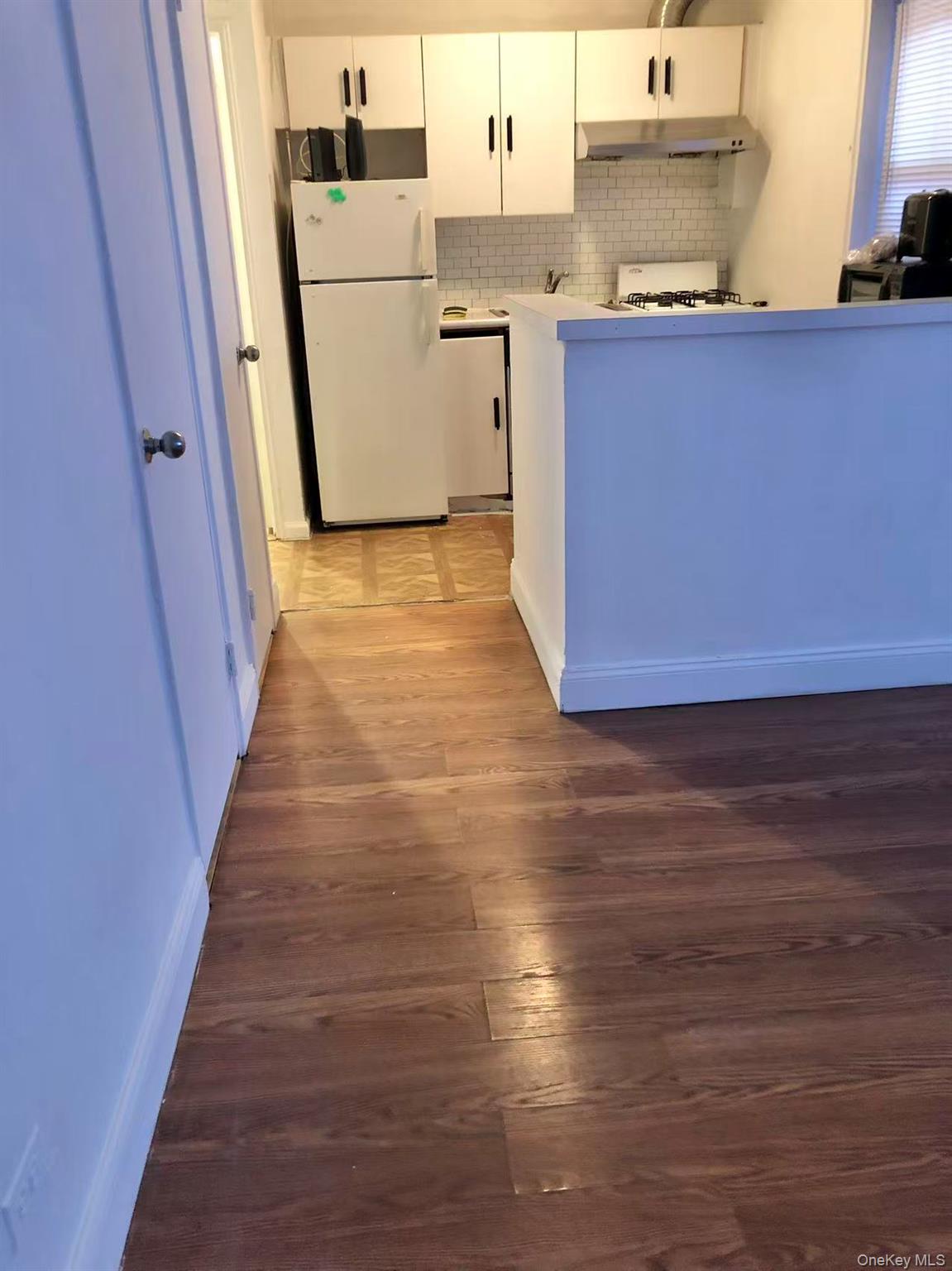 150-25 72nd Road, Unit 1L Queens, NY 11367 - Photo 9 of 12 a view of a kitchen with wooden floor and electronic appliances