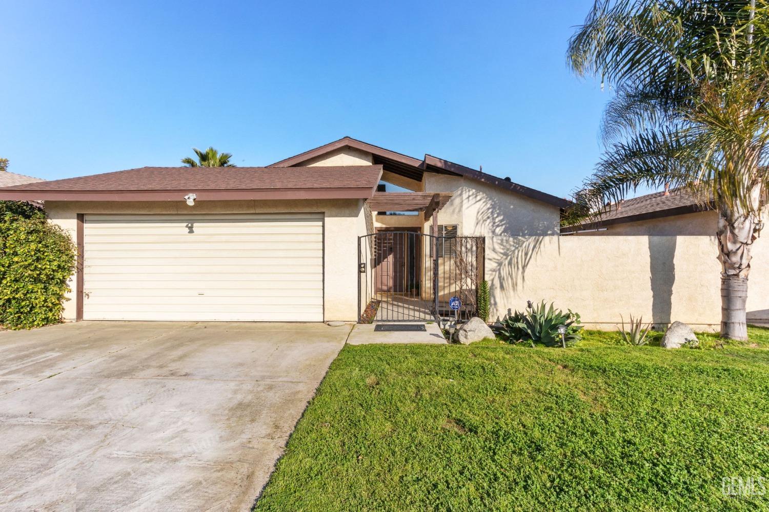 Undisclosed Address Bakersfield, CA 93309 - Photo 1 of 33 a front view of a house with a yard and garage