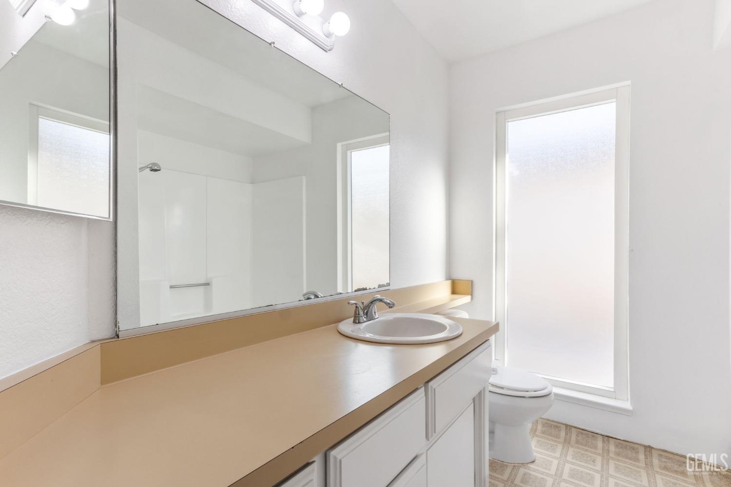 Undisclosed Address Bakersfield, CA 93309 - Photo 24 of 33 a bathroom with a granite countertop sink and a mirror