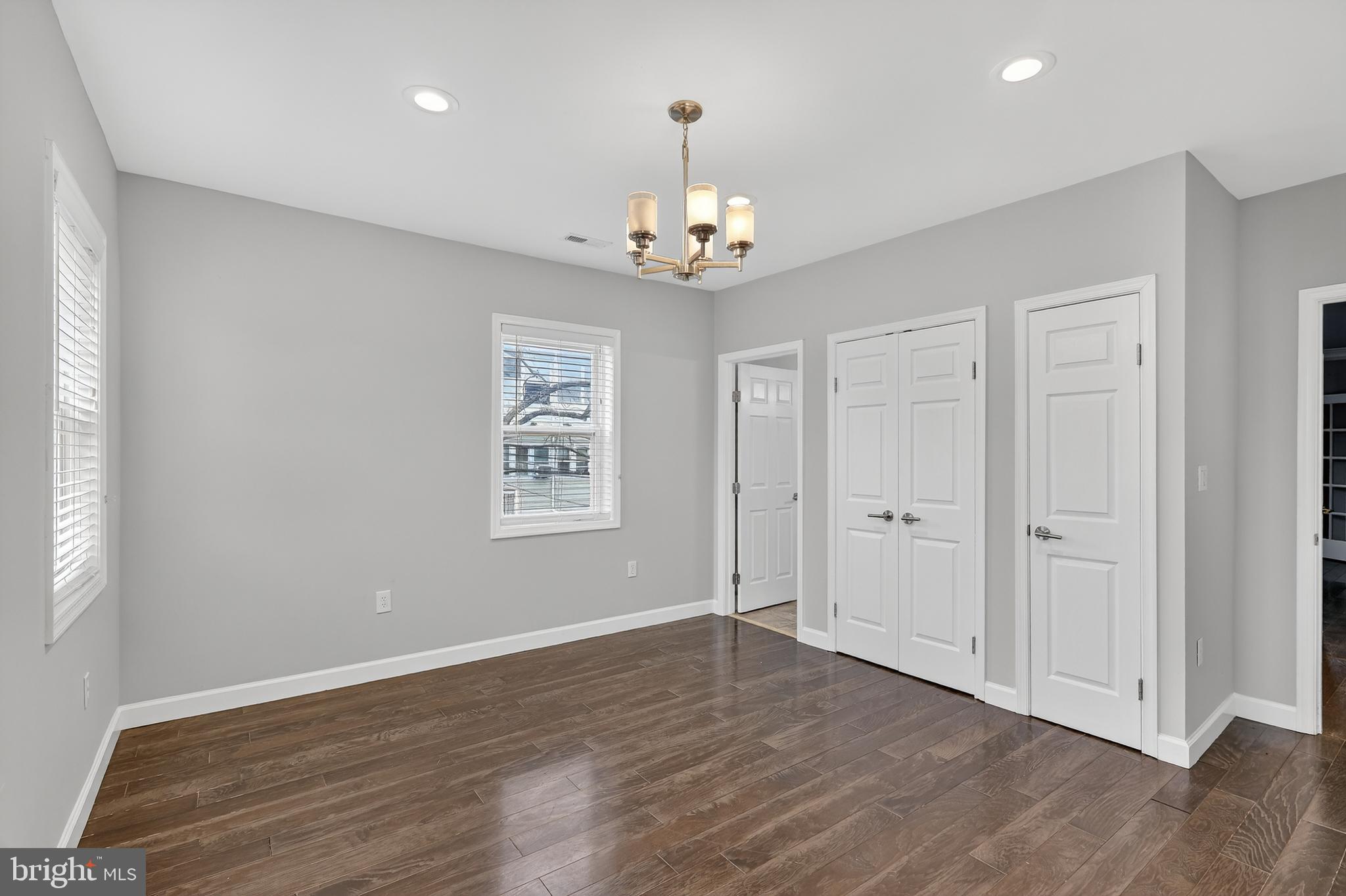 5619 1st Place Northwest, Unit 3 Washington, DC 20011 - Photo 14 of 23 an empty room with wooden floor chandelier fan and windows