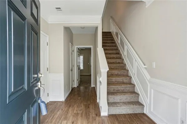 a view of a hallway with wooden floor and entryway