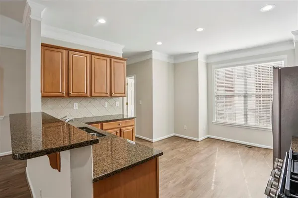 a kitchen with stainless steel appliances granite countertop a sink and a granite counter tops with wooden floors