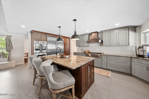 a kitchen with granite countertop a sink stove and refrigerator