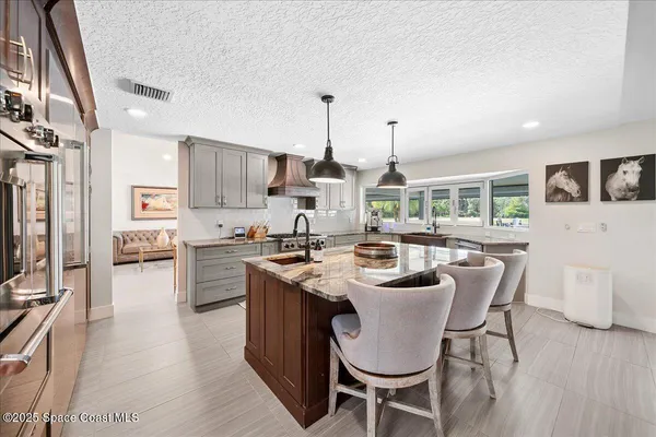 a kitchen with kitchen island granite countertop a table chairs microwave and cabinets