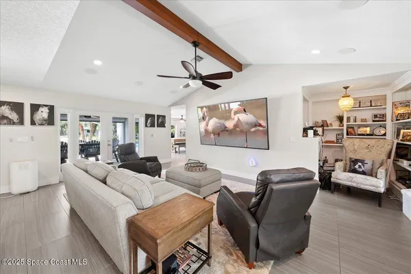 a living room with furniture and a view of kitchen