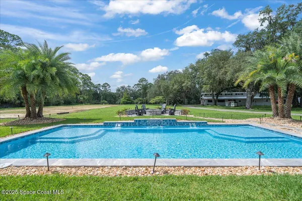 a view of a house with swimming pool and porch with furniture