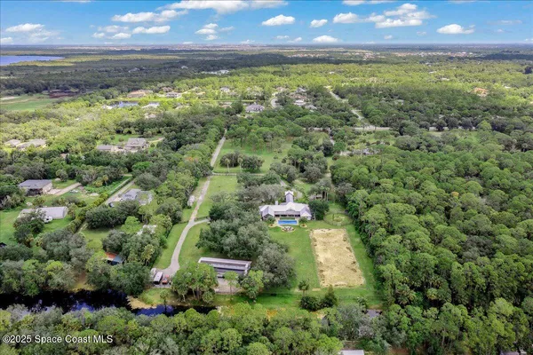 a view of a house with potted plants and a table and chairs