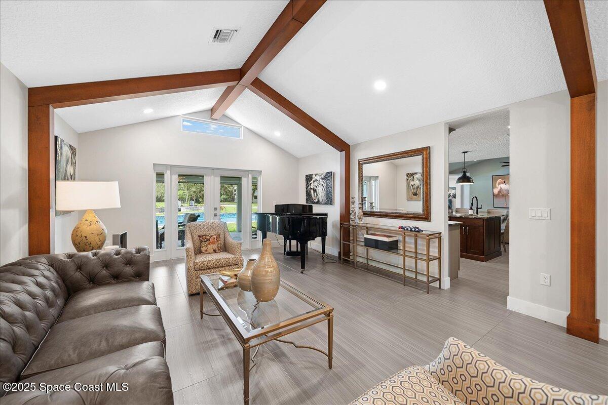 5685 Lake Washington Road Melbourne, FL 32934 - Photo 8 of 62 a living room with furniture a wooden floor and a large window