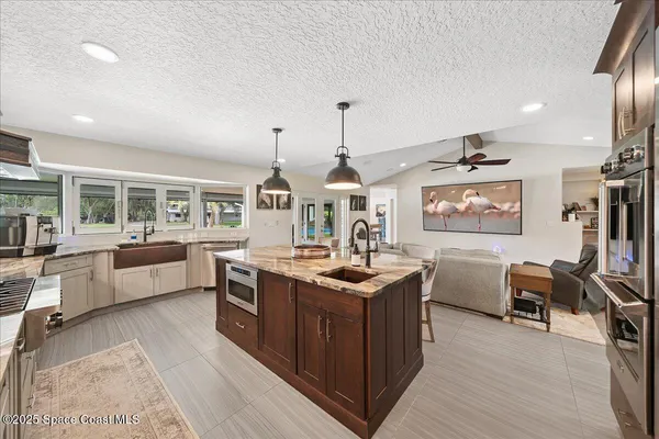 a kitchen with stainless steel appliances granite countertop a stove and a wooden floors