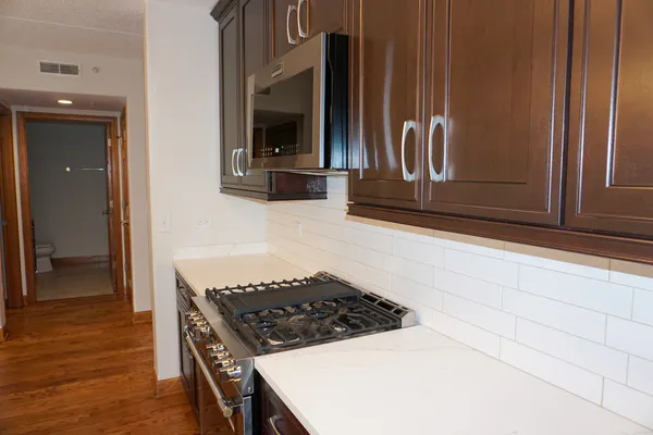 a large kitchen with stainless steel appliances granite countertop a sink and a stove