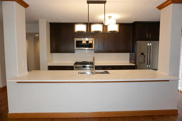 a view of a kitchen with stainless steel appliances a refrigerator and microwave