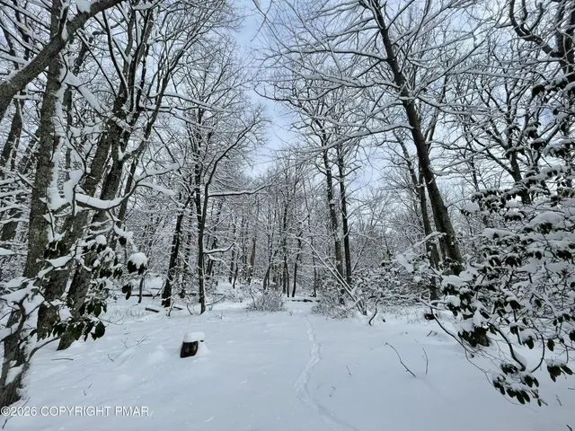 a view of white house with a yard covered in snow