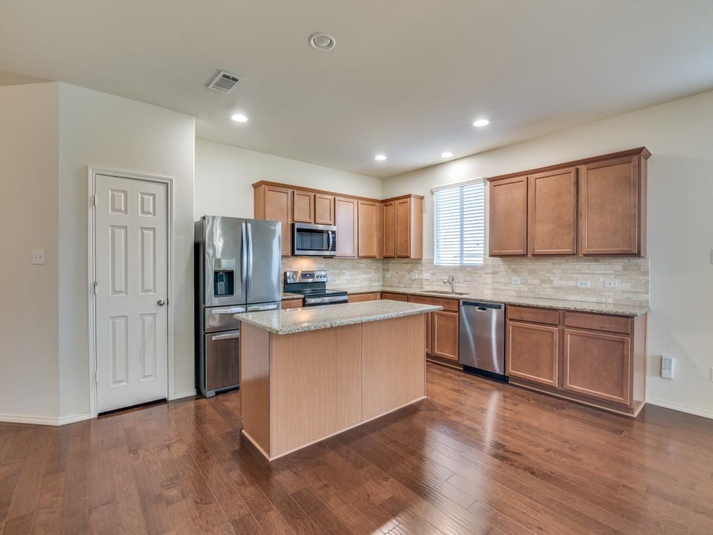 2232 Heaton Street Forney, TX 75126 - Photo 14 of 34 a kitchen with stainless steel appliances granite countertop a refrigerator and wooden cabinets