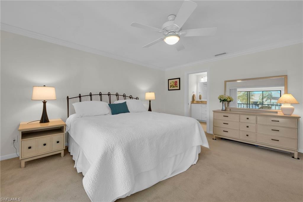 1100 9th Street South, Unit D201 Naples, FL 34102 - Photo 13 of 25 a bedroom with a bed and a night stand