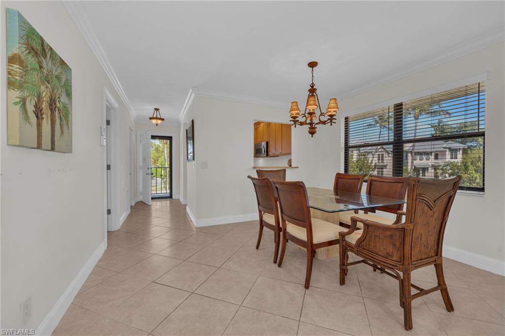 1100 9th Street South, Unit D201 Naples, FL 34102 - Photo 5 of 25 a view of a dining room with furniture and chandelier