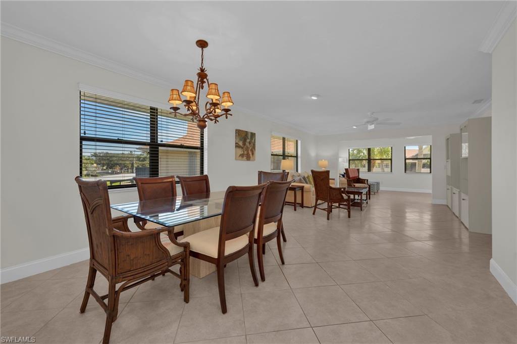 1100 9th Street South, Unit D201 Naples, FL 34102 - Photo 6 of 25 a dining room with wooden floor a chandelier a wooden table and chairs