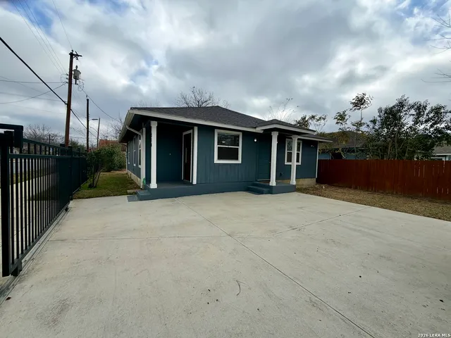 a view of a house with backyard and barbeque grill