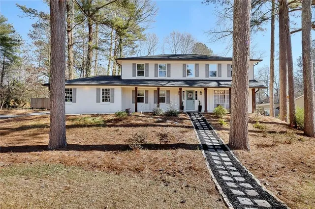 a view of a house with backyard and sitting area