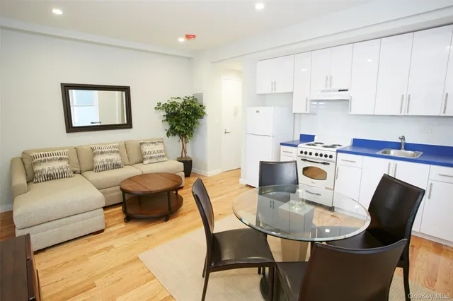 a kitchen with a table chairs a stove a microwave and cabinets