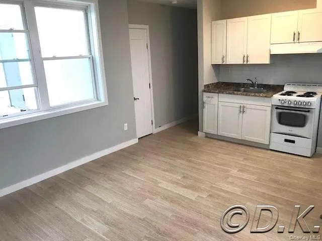 a kitchen with a stove a sink and a window