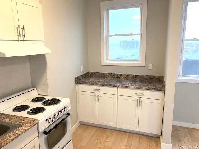 a kitchen with a stove a sink and a window