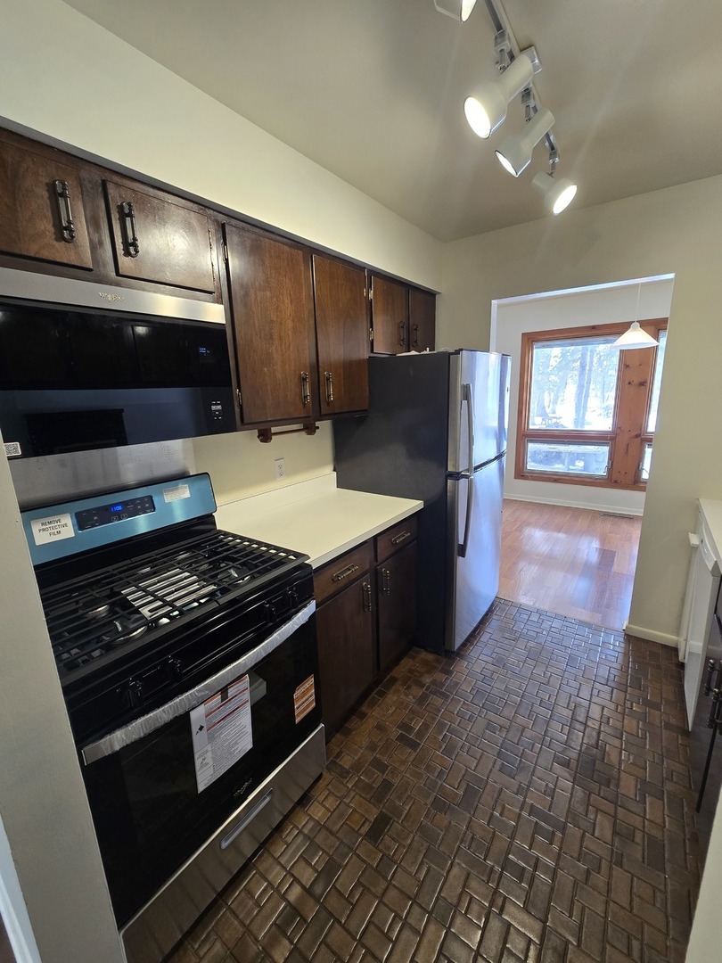 905 Hickory Road Woodstock, IL 60098 - Photo 15 of 32 a kitchen with stainless steel appliances granite countertop a stove a sink and a refrigerator